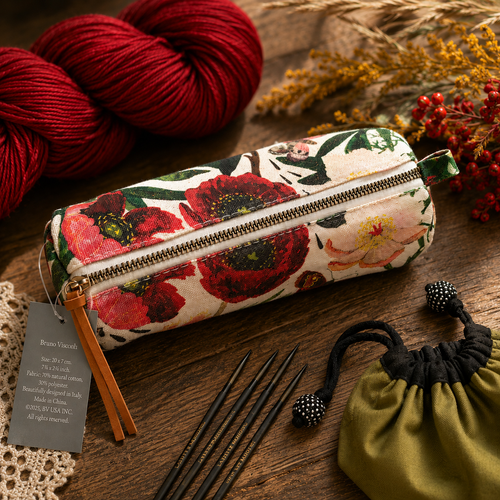 Bruno Visconti Canvas Knitting Notions Pouch with floral pattern, zipper closure, and leather tag on a wooden table with knitting tools.