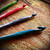 KnitPro Dreamz Wooden Crochet Hook Set, vibrant colorful handles in green, red, purple, and blue, on wooden background, showcasing hook tips.