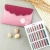 KnitPro Dreamz Deluxe Single Ended Wooden Crochet Hook Set, assorted colored hooks in a card, with pink pouch and nuts on gray background.