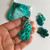 Teal Mindful Collection Stitch Markers, a mega pack of small, round markers on a hook, with matching teal pouch and scattered markers nearby.