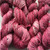 Pink hand dyed worsted weight wool yarn with black and brown neps