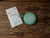 Knitters Pride The Mindful Collection Tape Measure,  green color with a white mandala design, features Forever Winding Wool branding and wooden background from Knitters Pride brand. Knitters Pride The Mindful Collection Tape Measure,  green color with a white mandala design, features Forever Winding Wool branding and wooden background from Knitters Pride brand.