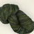 Luxury Blue Spruce Handspun Merino Yarn, DK Sport Weight, dark green with yellow and blue flecks, skein of artisan wool yarn.
