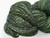 Luxury Blue Spruce Handspun Merino Yarn, DK Sport Weight, speckled green, blue, and yellow hues, twisted skein, showcasing artisan craftsmanship.