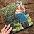 Malabrigo Pattern Book #9 Niños kids sweater vests hats designs cover  with a young girl wearing blue, red, and white sweater.