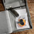 Karbonz Interchangeable Knitting Needle Set - 4.5" Midi, gray case open with needles and accessories inside, on a wooden surface.