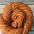 Handmade Butterscotch Merino DK Weight yarn from artisan brand 56, a luxury yarn, featuring twisted strands in warm golden brown color of luxury natural fibers for knitting and crocheting.