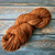 Handmade Art Yarn, Butterscotch Merino, DK Weight, artisanal luxury yarn in a warm, golden brown color, soft and chunky textured skein.