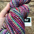 Forever Winding Wool Luxury Handspun Merino Wool Yarn Rainbow Fiesta, a multicolored skein in vibrant pink, purple, blue, and green hues, made from high-quality brand wool.