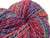 Luxury Handspun Merino Wool Yarn by Forever Winding Wool, Rainbow Fiesta colorway, vibrant multicolored skein featuring blues, pinks, purples, and yellows in a handspun merino wool yarn product.