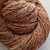 Luxury Handspun Merino Wool skein in Autumn Majesty, showcasing sport/DK weight, 2-ply yarn with warm brown, orange, and cream hues.