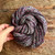 Luxury handmade merino wool yarn, Midnight Bloom by Forever Winding Wool, a gray skein with subtle purple and blue flecks, made from high-quality merino wool yarn.