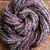 Luxury Handmade Merino Wool Yarn by brand Forever Winding Wool, Midnight Bloom skein features multicolored hues of purple, pink, blue, and white in a handspun merino wool yarn with natural textures.
