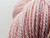 Forever Winding Wool Artisan Merino Wool Yarn, Pink Opal, showcasing soft pink and white hues with subtle variations in tone, presented in a skein with clear texture and twist, highlighting the yarn's natural fiber and color blend.
