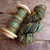 Luxury Merino wool yarn, green and orange hues, Mountain Twilight, light worsted weight DK, on wooden spool and skein.