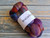 Malabrigo Nube Marte 100% Merino wool roving bundle, multicolor shades of purple, orange, and blue, 4oz weight, perfect for spinning and felting fibers, natural textile material, yarn.