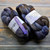 Malabrigo Nube Cirrus Gray, Merino wool roving, 4oz, gray, blue, and brown hues, spinning and felting fiber, labeled Malabrigo with purple tag.