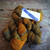 Malabrigo Rios Glitter yarn, Bronze Gold Worsted Merino, skein of orange, brown, and gold yarn with label reading 048 Glitter.
