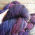 Malabrigo Rios Yarn in Syrah Grapes, deep wine purple hand-dyed worsted merino skein, showcasing rich plum and burgundy hues in a twisted .