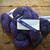 Malabrigo Worsted Violetas purple hand-dyed merino wool yarn skein with label, showcasing rich plum color and twisted texture.