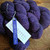 Malabrigo Worsted Violetas purple hand-dyed merino wool yarn skein with tag, showcasing rich plum color and textured fiber.