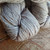 Malabrigo Worsted Pearl yarn, soft white merino wool skeins, showcasing gentle texture and subtle sheen on a rustic wooden surface.