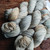 Malabrigo Rios Magnolia 263 Neutral Worsted Merino Yarn skeins in soft cream and light gray hues, showcasing subtle color variations.