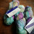 Malabrigo Rios yarn skeins in Melissa color, Superwash Merino Worsted yarn, pastel purple, blue, and green hues, displayed on wooden surface.