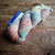 NEW Malabrigo Rios RIO-267 Zahara Superwash Merino Worsted Yarn, multicolored yarn with pink, blue, and cream hues on a wooden surface.