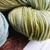 Malabrigo Rios Gardenia Superwash Merino Worsted Yarn skein in a soft green hue with subtle white undertones, showcasing texture and color.