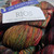 Malabrigo Rios yarn in Sagittarius color, a muted rainbow merino wool with multicolored strands of red, orange, yellow, green, and blue, from the brand Malabrigo, displayed in a skein with a label and tag. Malabrigo Rios yarn in Sagittarius color, a muted rainbow merino wool with multicolored strands of red, orange, yellow, green, and blue, from the brand Malabrigo, displayed in a skein with a label and tag.