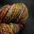 Green Prism Bulky Handspun Merino Yarn, Luxury 2-Ply Artisan Wool skein in multicolored green, pink, orange, and yellow hues on dark background.