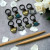 Handcrafted enamel teacup stitch markers for knitting and crochet on 10mm black rings.