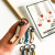 Handheld view of colorful enamel sock stitch markers showing the dainty 10mm ring size.
