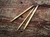 Brittany Birch Wood Cable Needles, 3 handcrafted birch wood knitting needles, light brown, on rustic wooden background, showcasing natural texture and color.