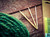 Brittany Birch Wood Cable Needles, 3-Piece Handcrafted Knitting Notions, birch wood knitting needles on wooden background with green yarn.