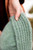 Hand holding green knitted beanie with ribbed texture, pattern from Laine Publishing's 52 Weeks of Accessories collection.