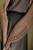 Brown crocheted scarf with intricate patterns draped over a dark grey dress, showcasing beautiful handmade knitwear design for year-round styling.
