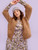 Woman wearing brown chunky knit cardigan, gray beanie, and floral dress against light purple background, showcasing 52 Weeks of Easy Knits patterns.