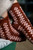Brown and pink patterned socks on a person's feet, featuring beautiful knitting designs from 52 Weeks of Socks Vol. II book.