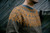 Strands of Joy knitting pattern sweater, orange and grey colourwork design, adult male model, crew neck, long sleeve, fair isle knitwear.