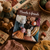 Mouche & Friends: Seamless Toys to Knit and Love book cover with colorful knitted animals and toys on a wooden background surrounded by yarn and crochet items.