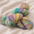 Malabrigo Vientos Yarn skeins in variegated rainbow colors, pastel hues of purple, yellow, green, and blue, soft and vibrant tones.