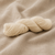 Malabrigo Vientos Yarn in a soft cream color, neatly twisted, on a beige linen background, showcasing its texture and gentle hue.