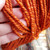 Bittersweet Bulky Handspun superwash Merino Yarn, vibrant burnt orange color, thick and chunky texture, held in a hand showing its softness.