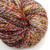 Handspun Merino Wool Yarn Treasures, multicolored yarn with shades of red, blue, yellow, and cream, neatly coiled.