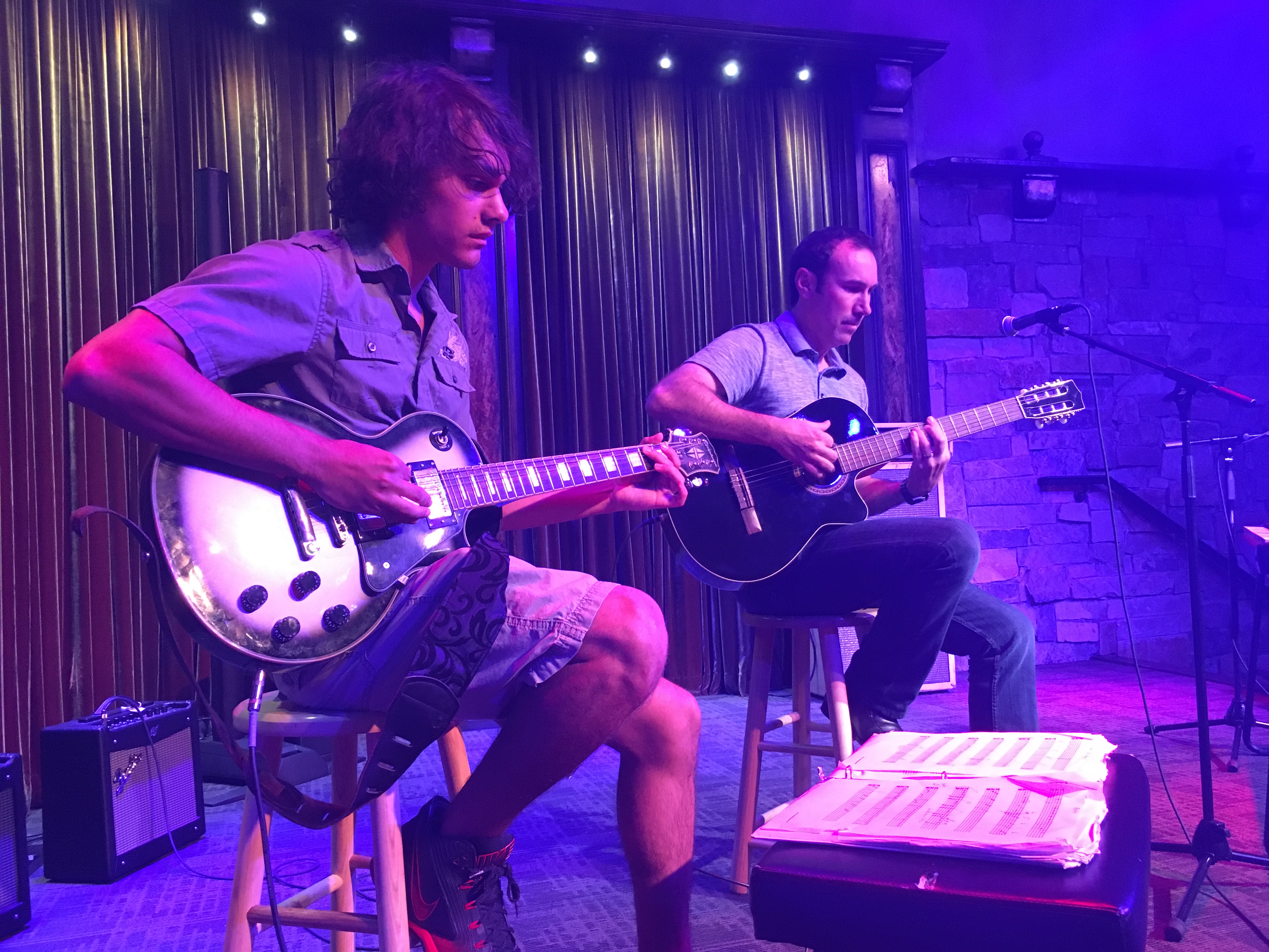 a couple of men playing guitars