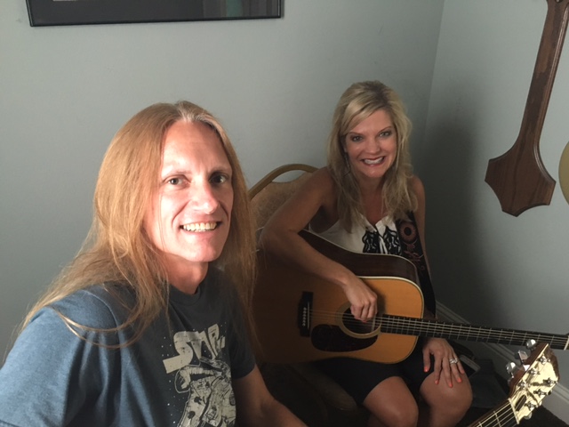 a couple of women smiling and playing guitars