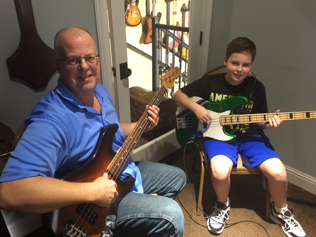 a person and a boy holding guitars