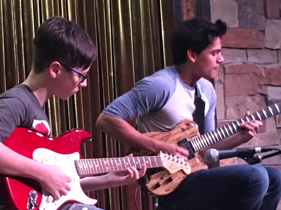 a couple of men playing guitars